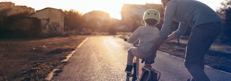Vader met kind leren fietsen